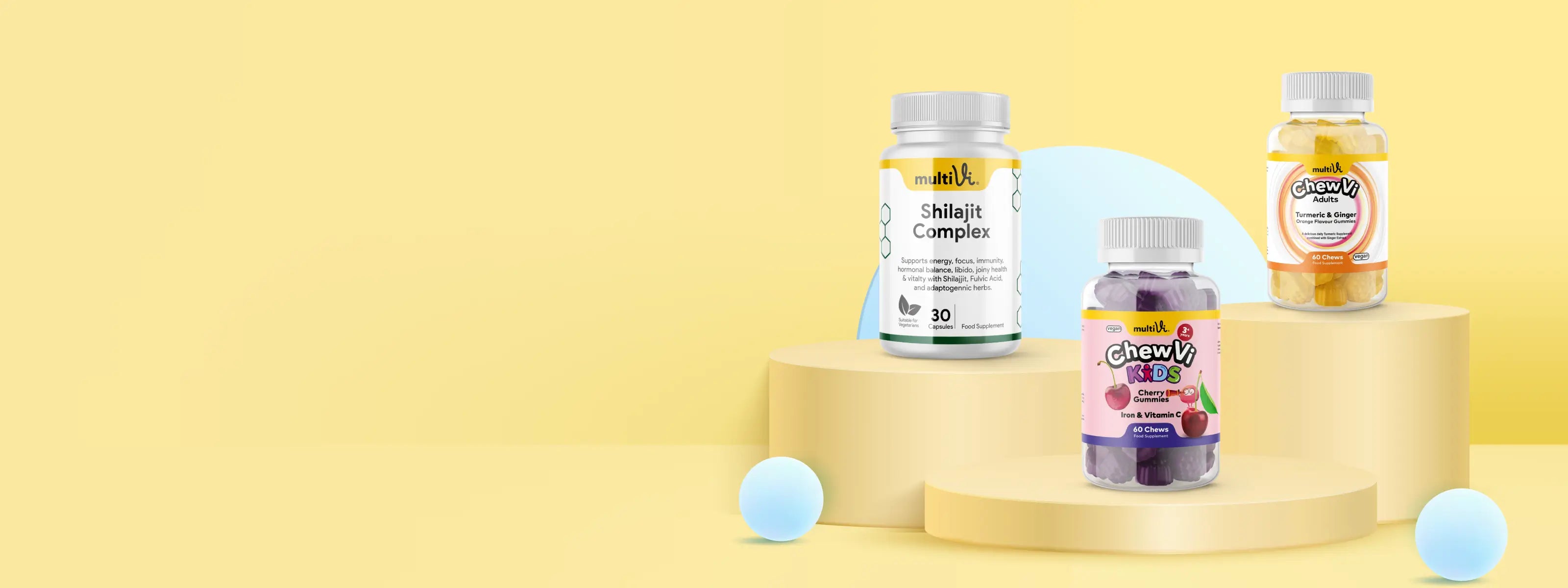 Three Multivi supplement bottles on a cylindrical platform with a yellow background
