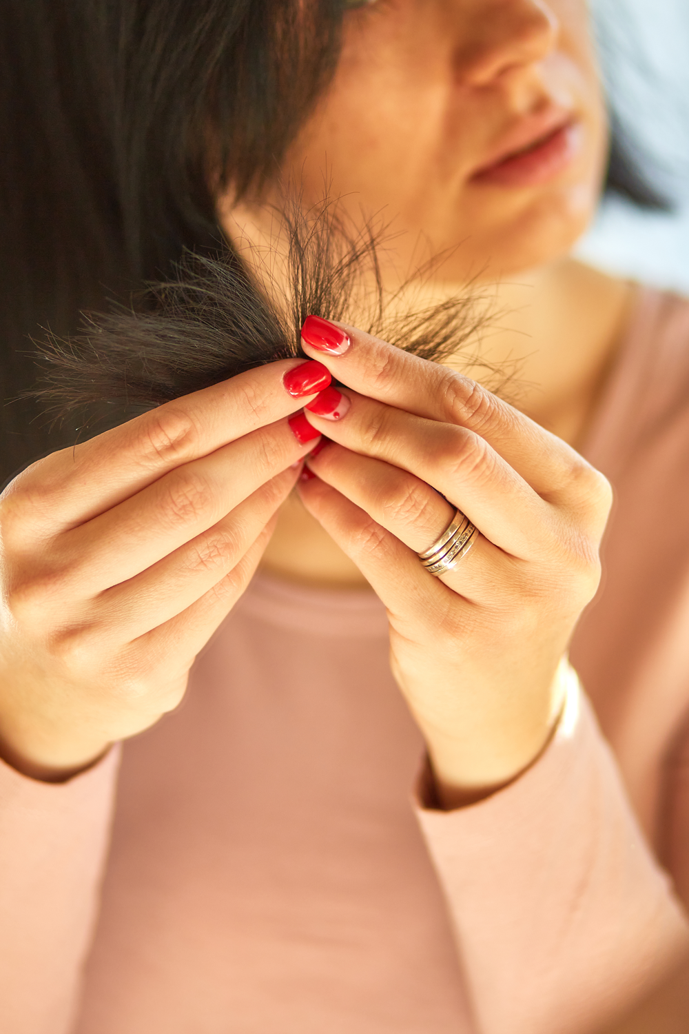 Woman holding damaged hair with a blurred background