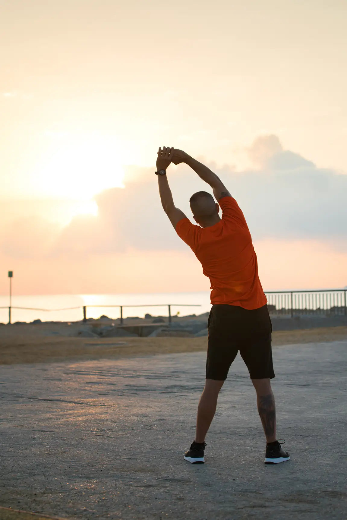 Person stretching outdoors with a sunset in the background
